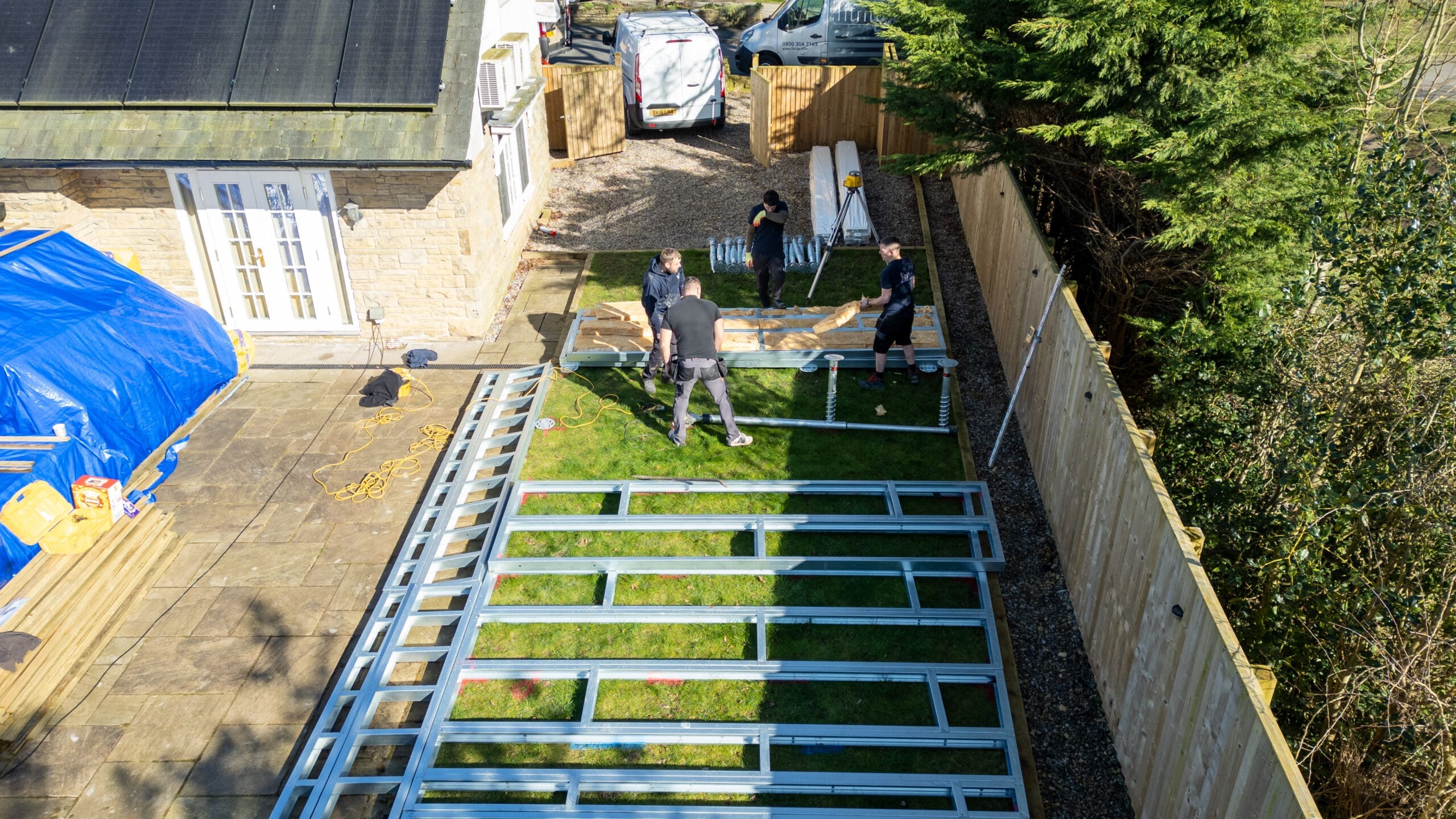 Fitrite installation team building steel decking subframe in residential garden from aerial view