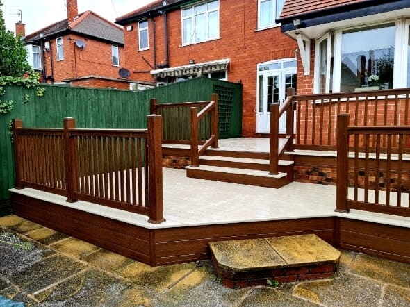 Raised uPVC decking platform with brown balustrade and steps fitted to red brick semi-detached house
